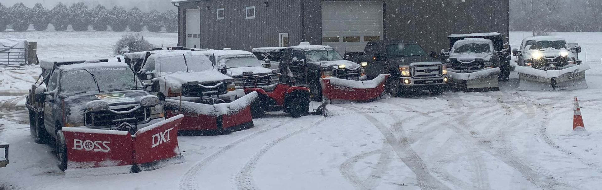pickup trucks lined up for commercial snow removal service with snow falling in southeast michigan