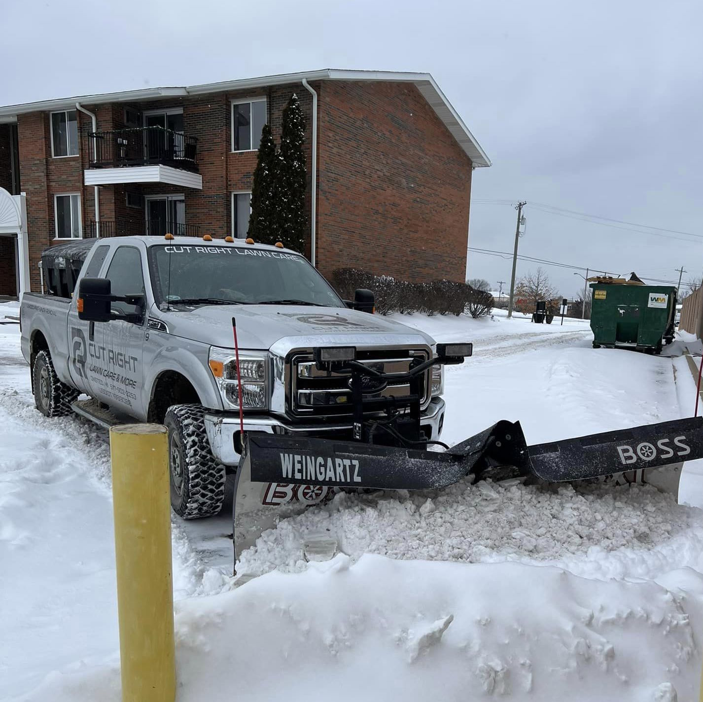 commercial snow plowing at apartment complex using pickup truck with plow attachment